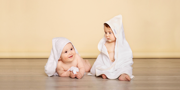 two cute babies wearing nordic print hooded bath towels